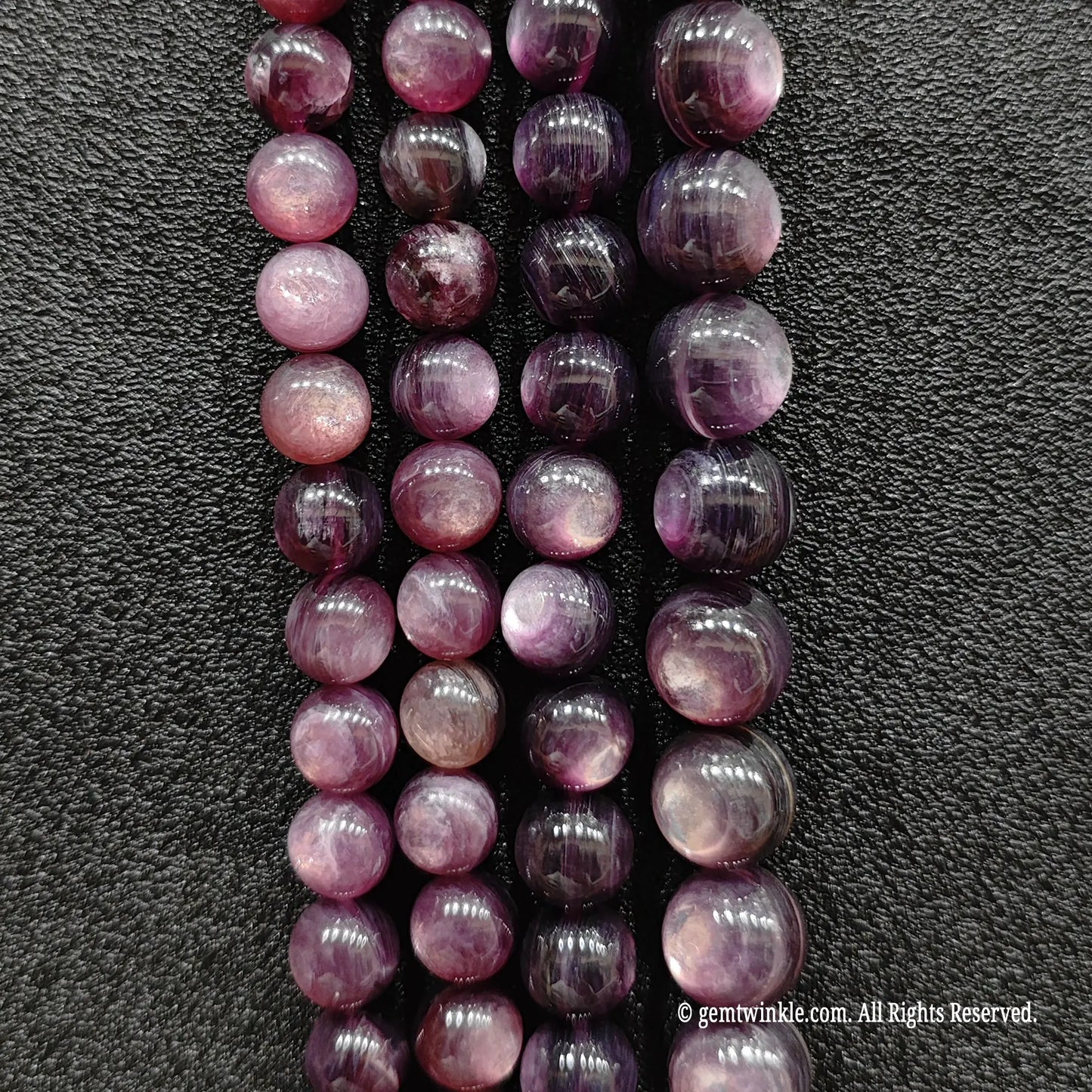 Purple lepidolite crystal beads strands displaying delicate lavender color shades under direct lighting
