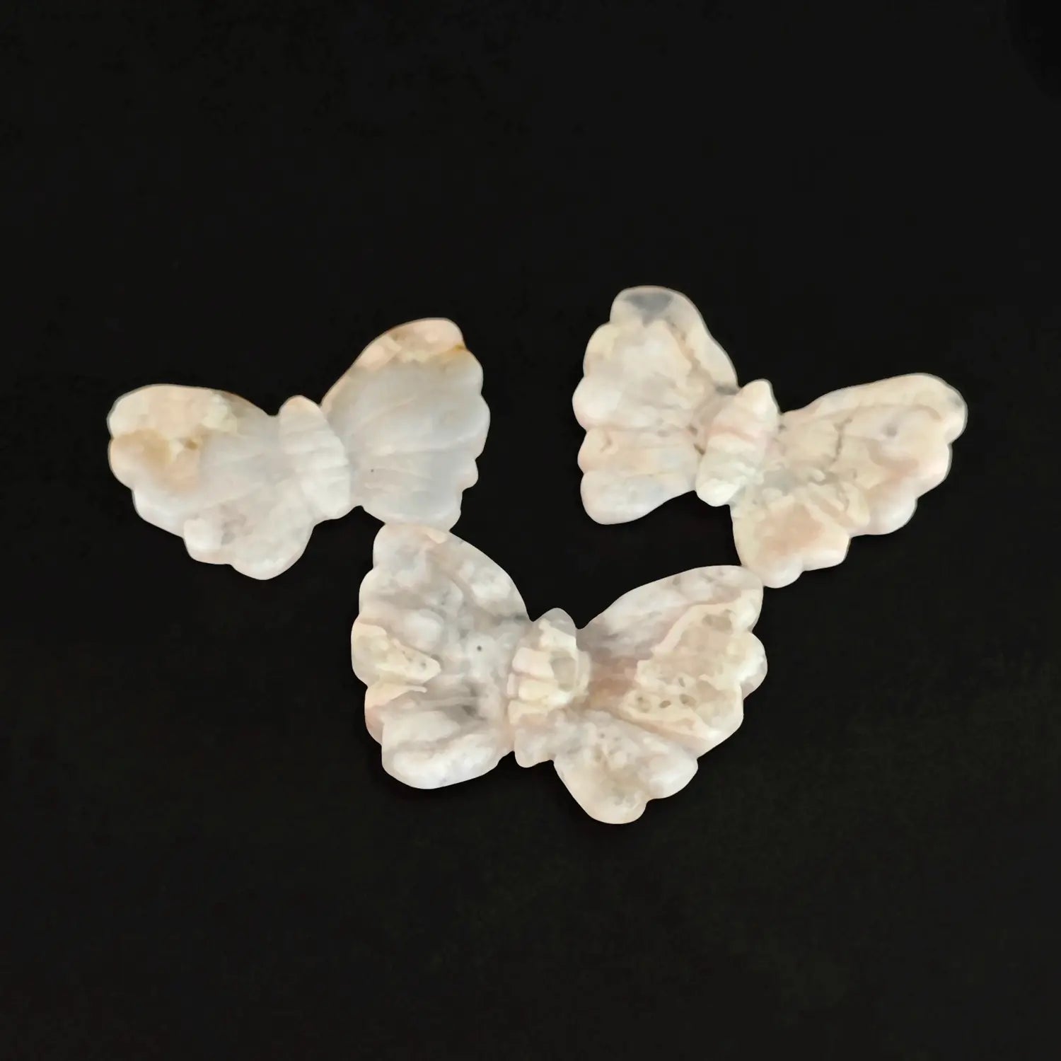 Wholesale 5cm natural flower agate butterfly figurines showing creamy pink chalcedony blooms in translucent matrix