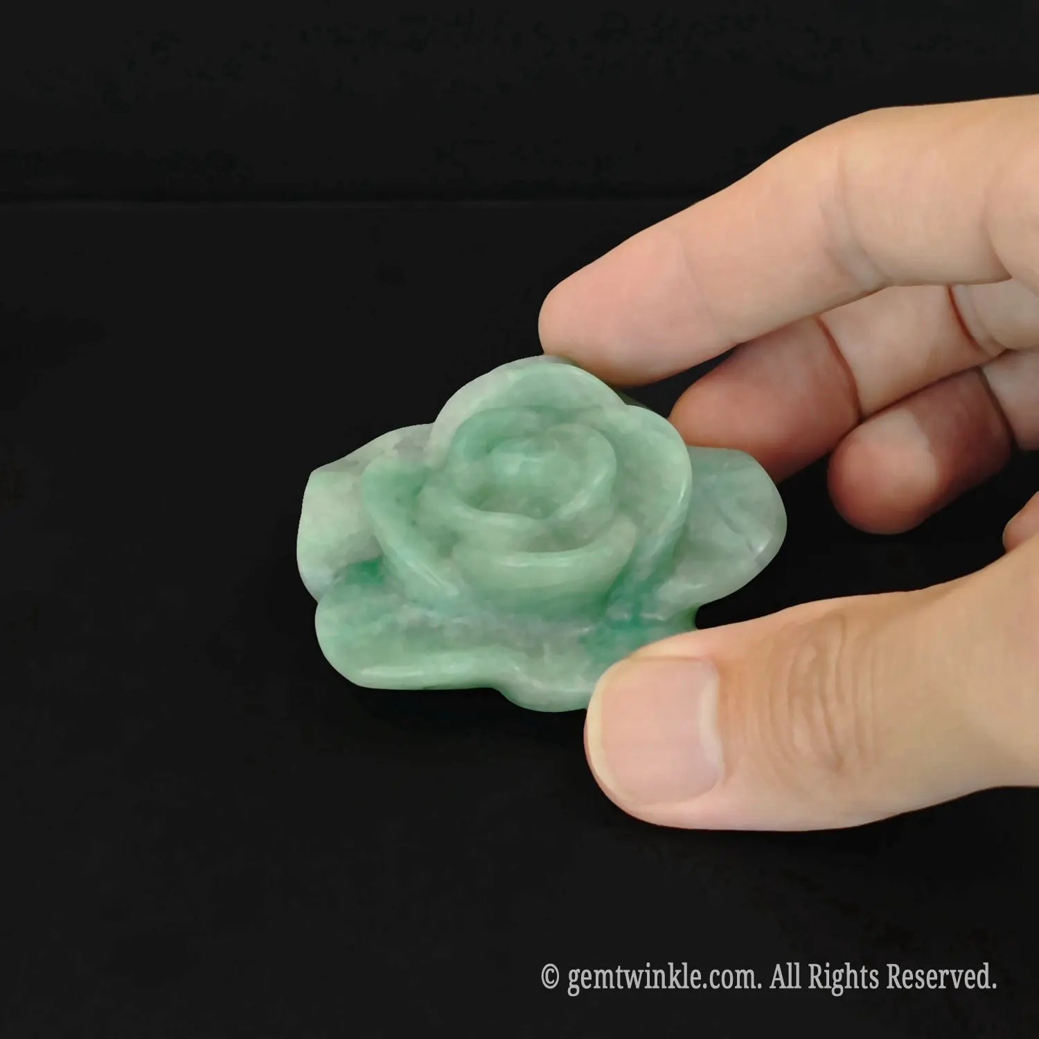 Hand-sculpted green aventurine crystal rose blossom carving held in hand demonstrating rich jade green color tone