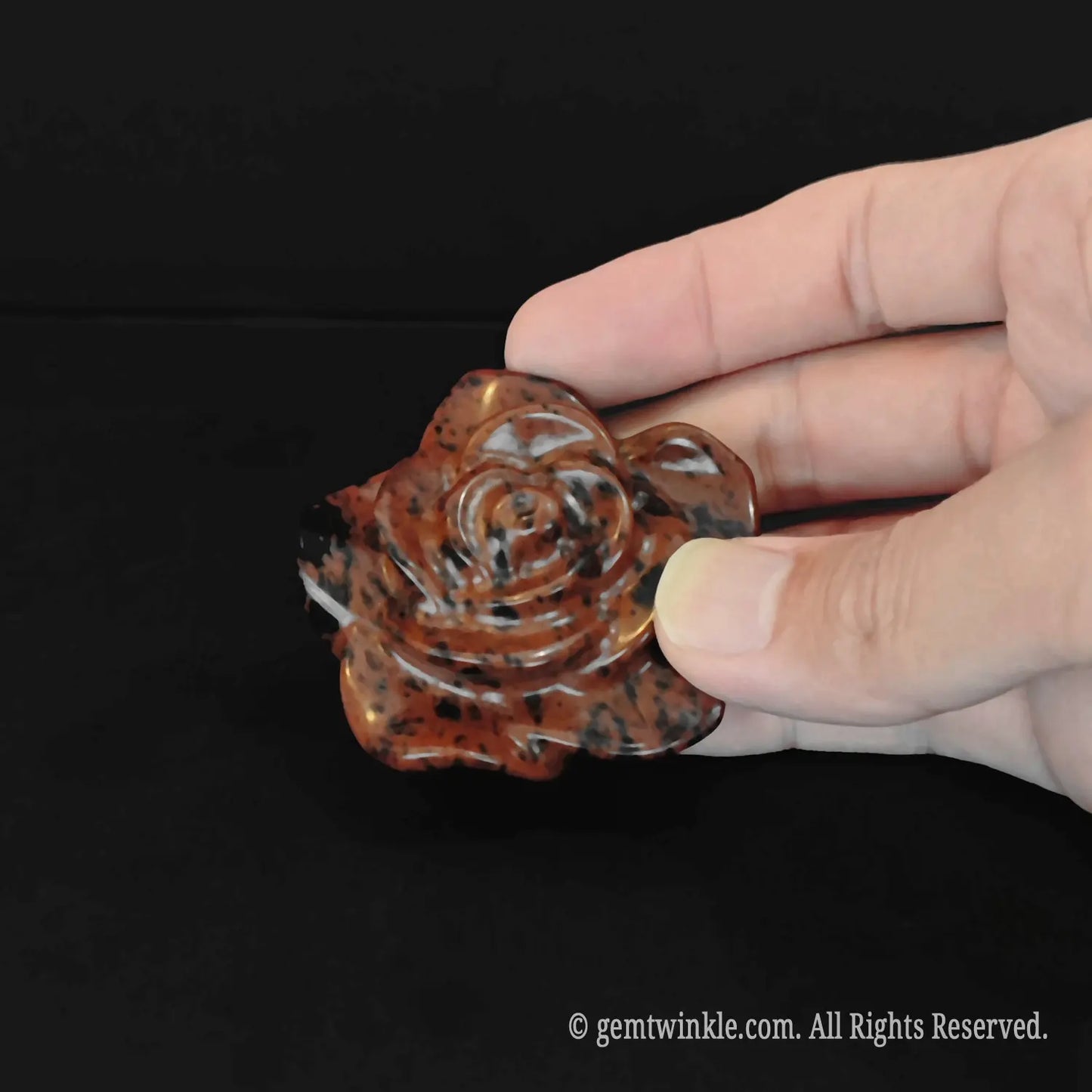 Front view of hand polished mahogany obsidian rose flower pocket totem with beautiful red and black metallic bands