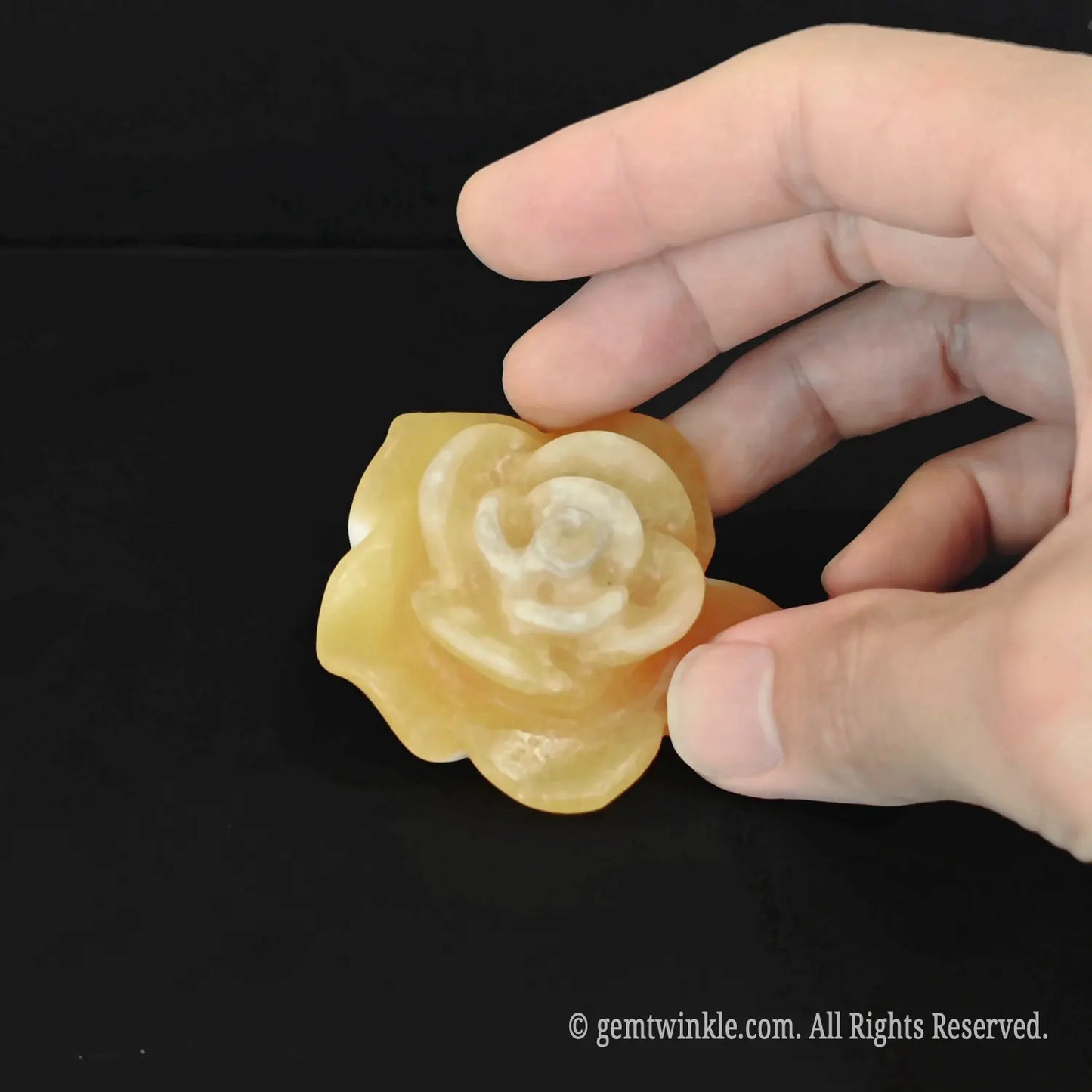 Polished honey yellow calcite flower figurine mini sculpture held in hand showing organic waxy luster details