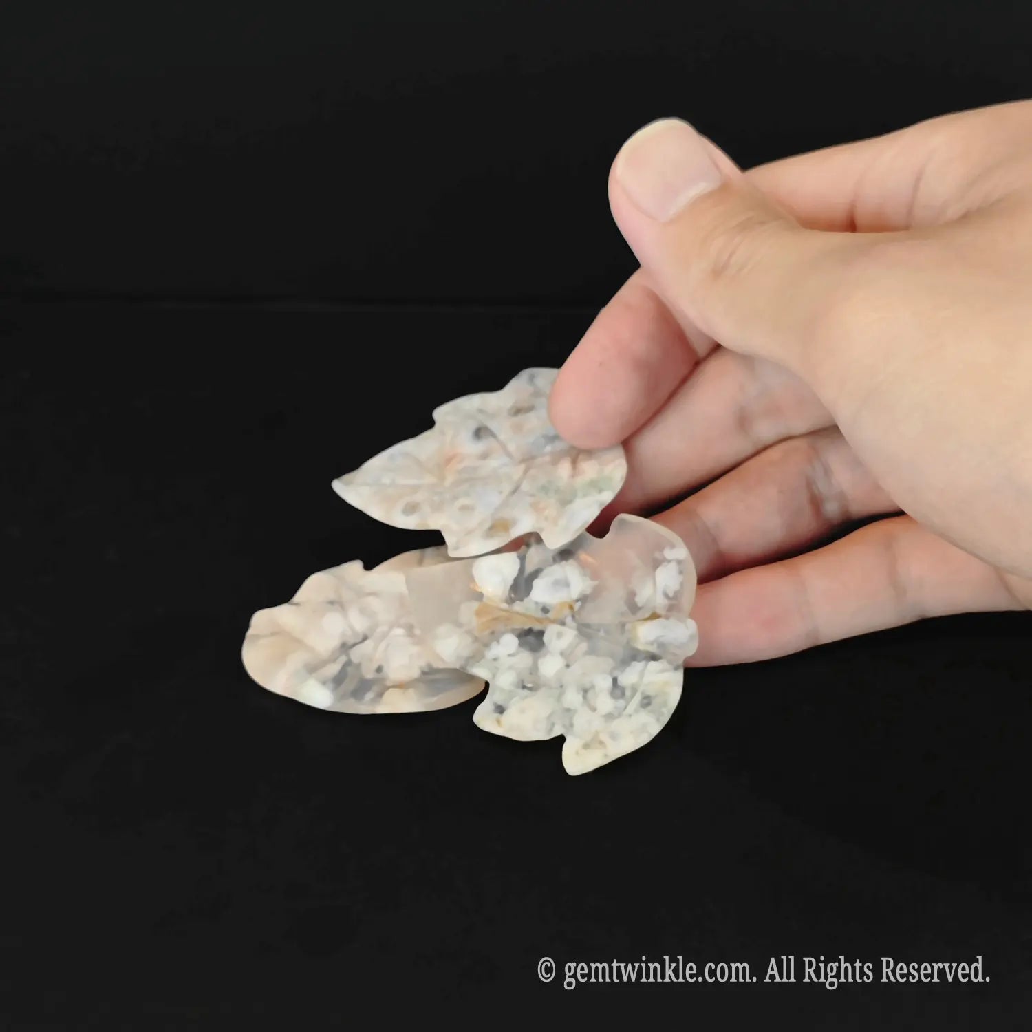 Natural untreated flower agate maple leaf figurine pocket totem held in hand showing translucent chalcedony matrix