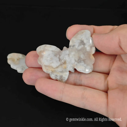 Natural untreated flower agate butterfly pocket totem held on palm demonstrating direct crystal wholesale quality