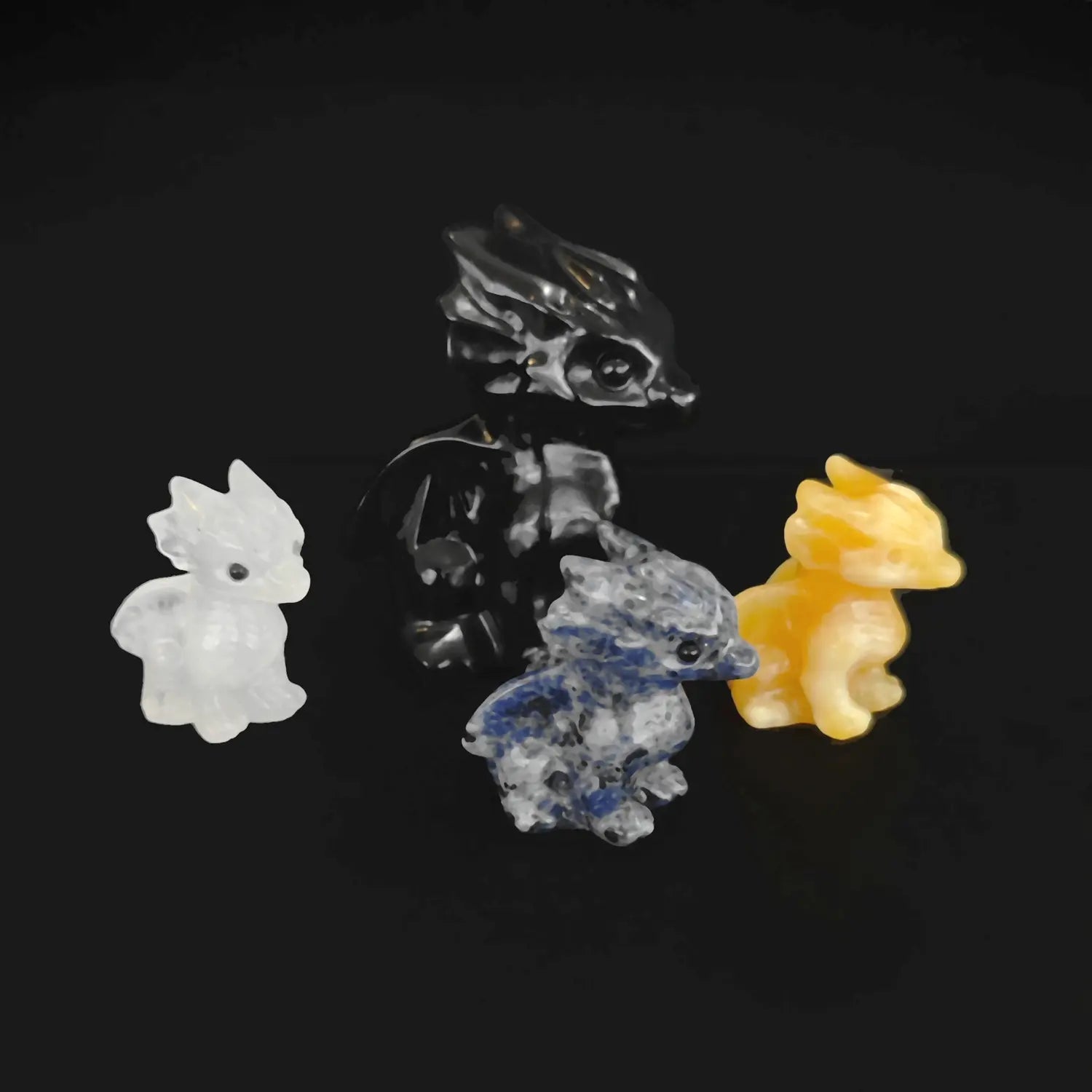 An assortment of wholesale gemstone baby dragon with wings figurines in black obsidian milky quartz yellow calcite and sodalite