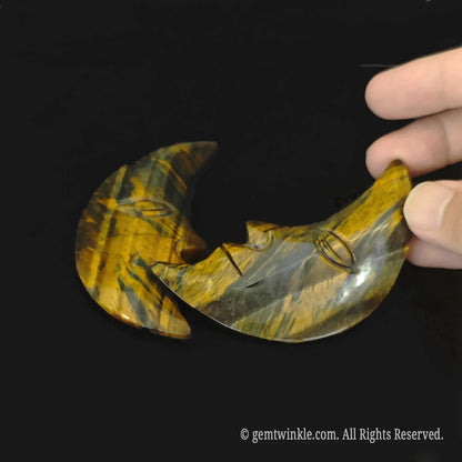 Profile view of a natural chatoyant crescent moon carving showing the detailed facial features