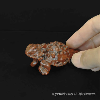 Polished mahogany obsidian lizard figurine animal totem showing detailed shiny black and red volcanic glass textures