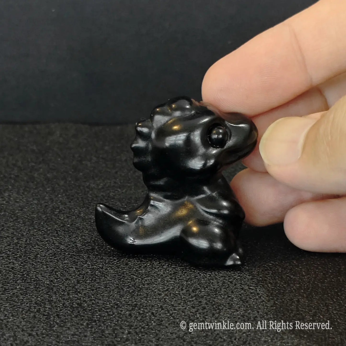 Close up view of miniature black obsidian dragon carving pocket desk totem for crystal boutique store inventory
