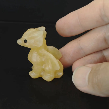Angled side profile of a waxy yellow calcite baby dragon carving emphasizing the vibrant honey tone and spiky horn lines