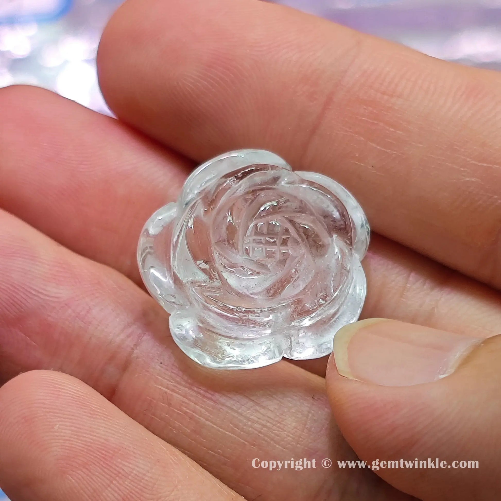 Handheld top view of genuine rock crystal rose flower blossom charm bead showcasing its layered petal profiles
