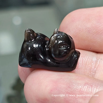 Front view of genuine silver sheen obsidian yoga cat charm bead showing size proportions and drill hole position on hand