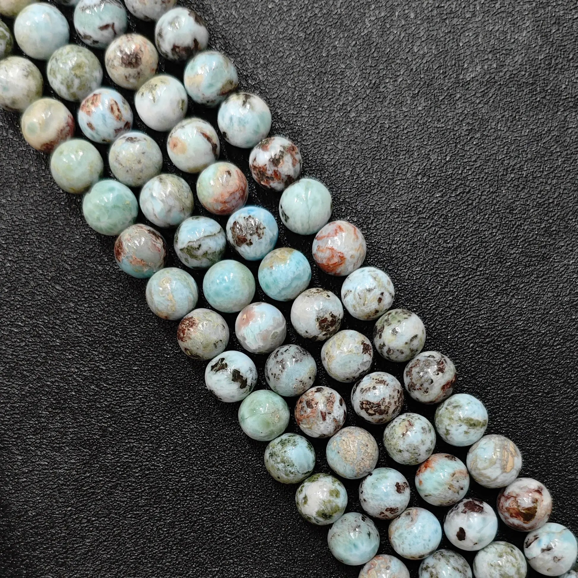 Genuine larimar crystal beads grade c showing rustic brown matrix patterns in bulk strands