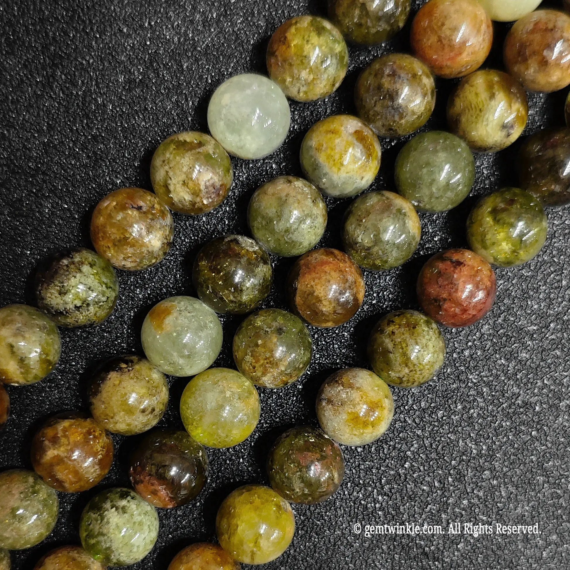 close look of natural green garnet gemstone round beads showing organic inclusions
