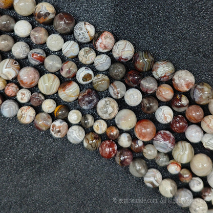 Multiple strands of raw color mexican striped lace agate loose crystal beads highlighting high polish spherical finish for boutique shop sourcing