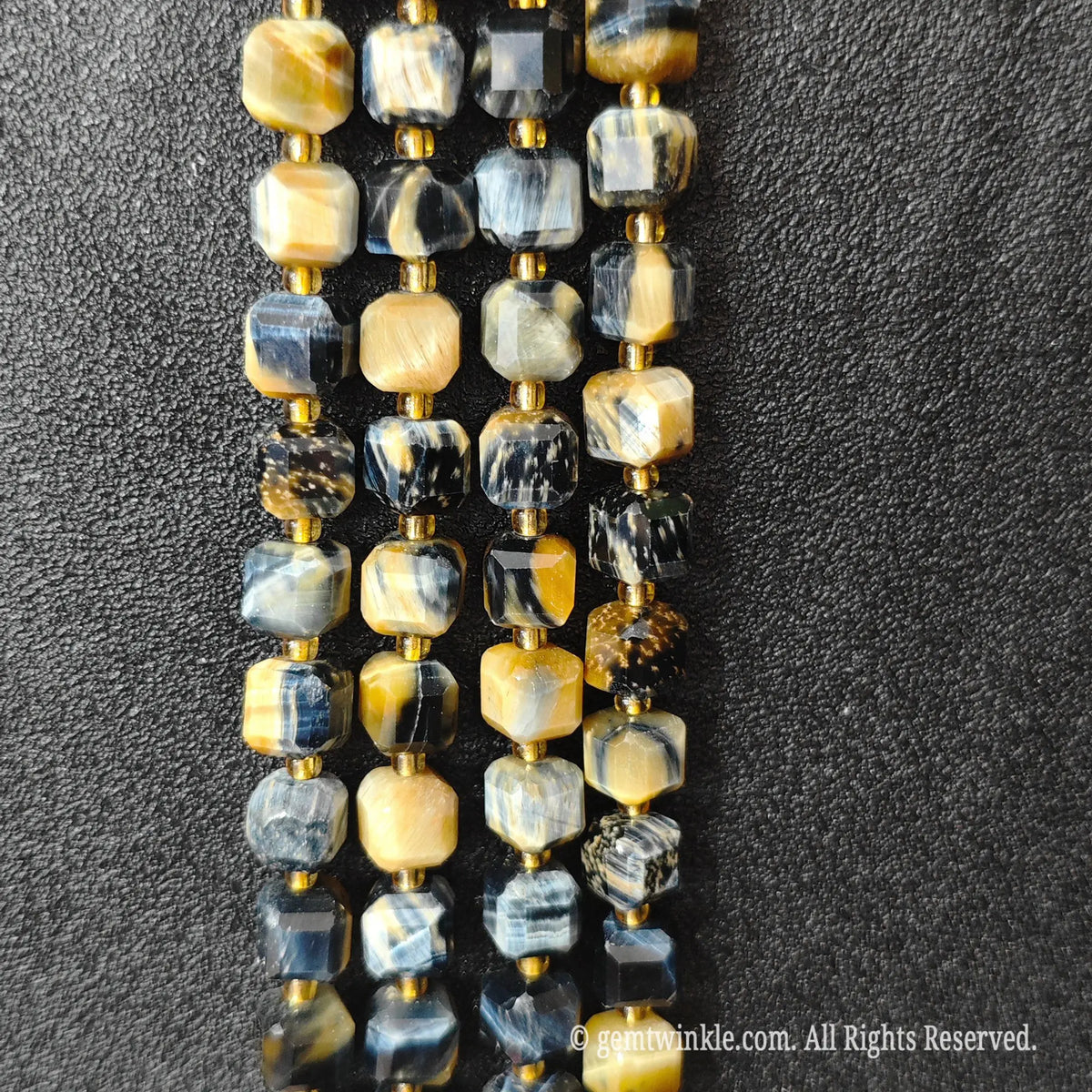Angled view of polished dreamy tiger eye square beads highlighting clean center drill holes