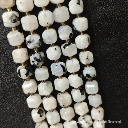 Angled view of polished black inclusion moonstone square beads highlighting clean center drill holes