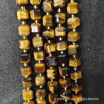 Angled view of polished golden tiger eye square beads highlighting clean center drill holes