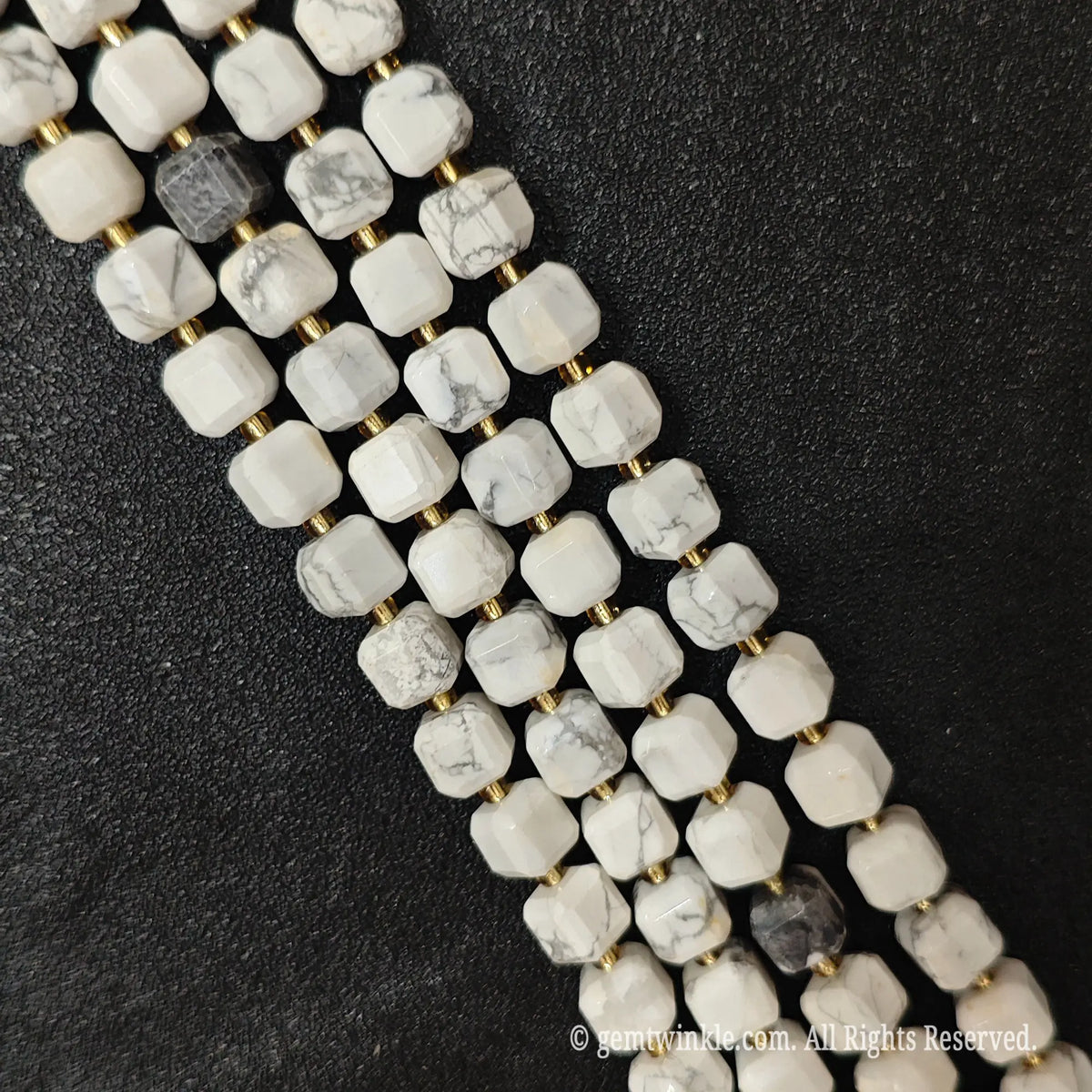 Angled view of polished white turquoise square beads highlighting clean center drill holes