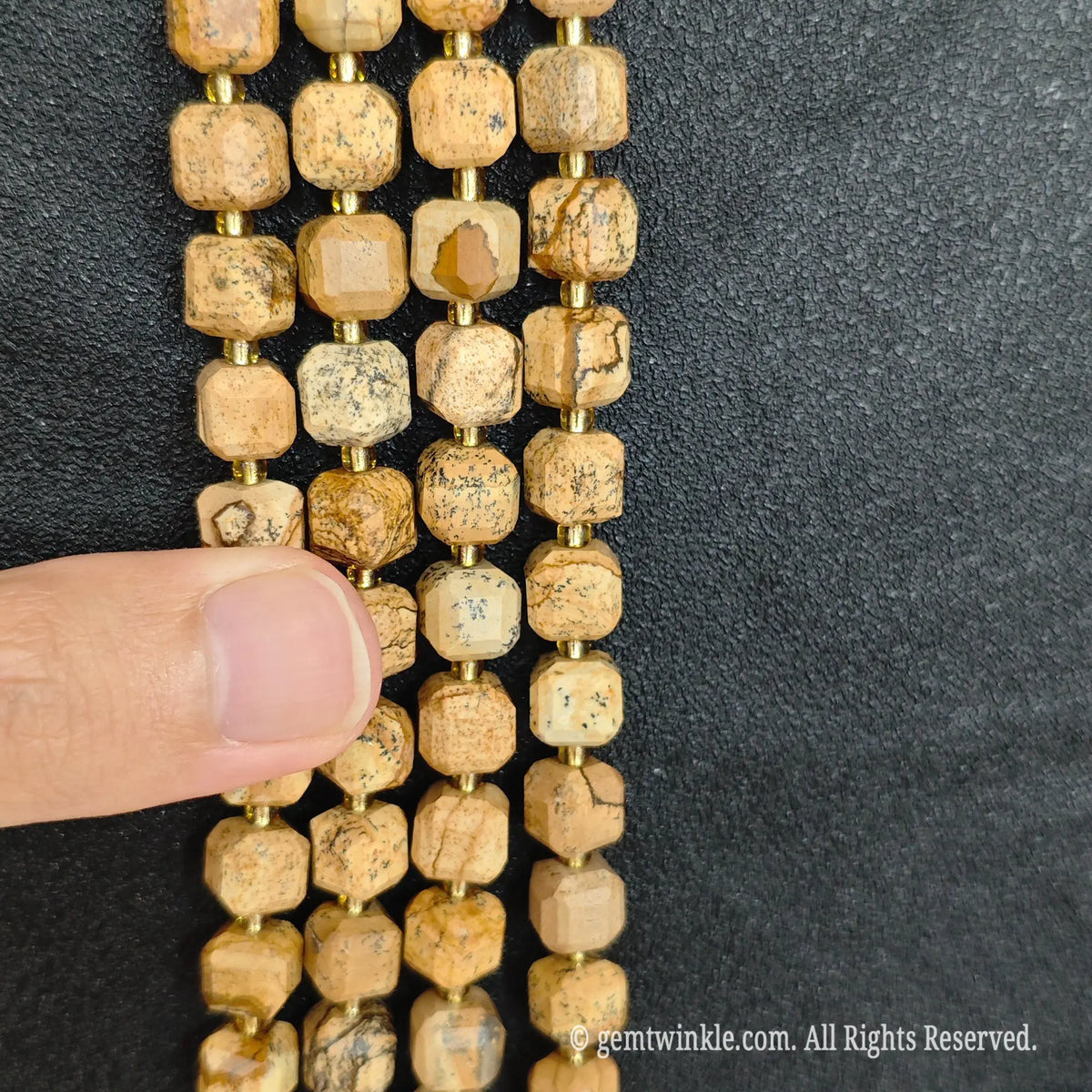 Angled view of polished wood grain stone square beads highlighting clean center drill holes