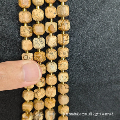 Angled view of polished wood grain stone square beads highlighting clean center drill holes