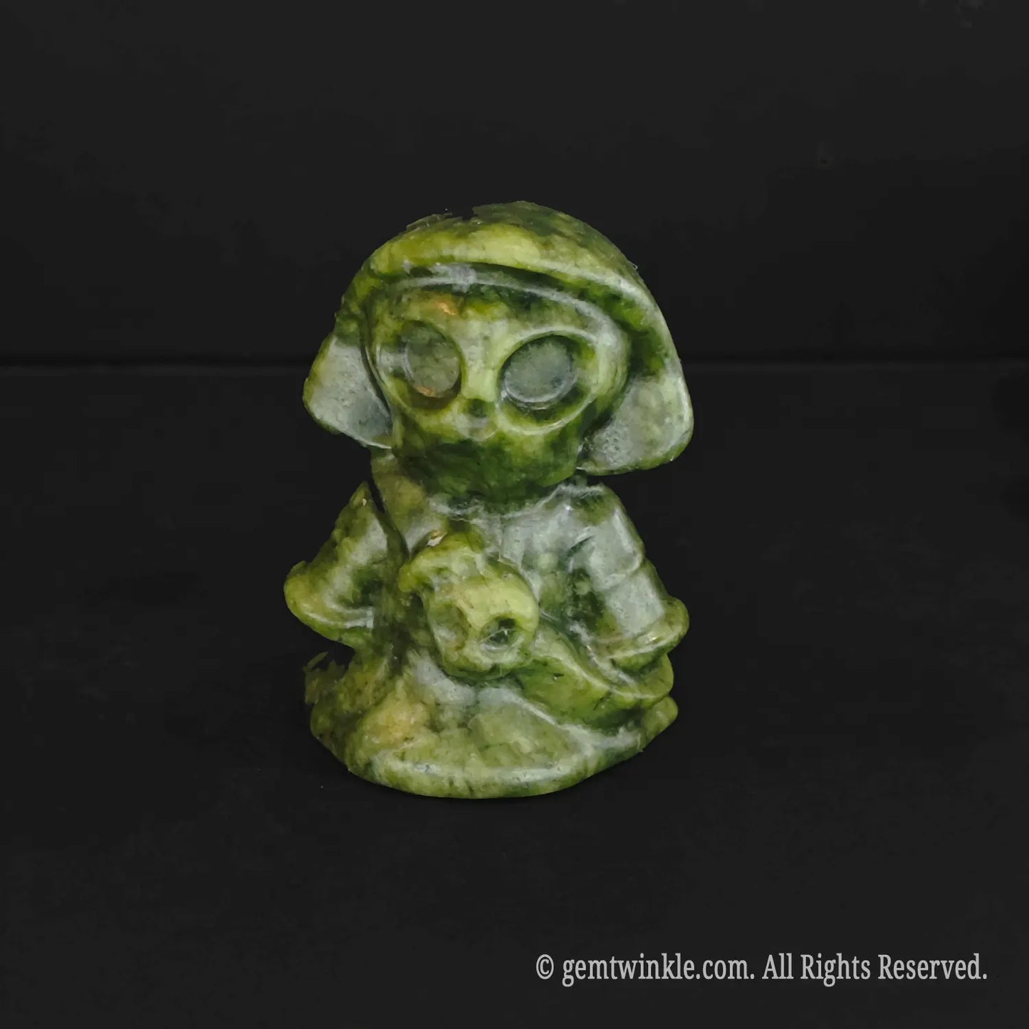 A standalone black obsidian chibi grim reaper carving featuring high reflective shine and detailed hollowed skull eyes