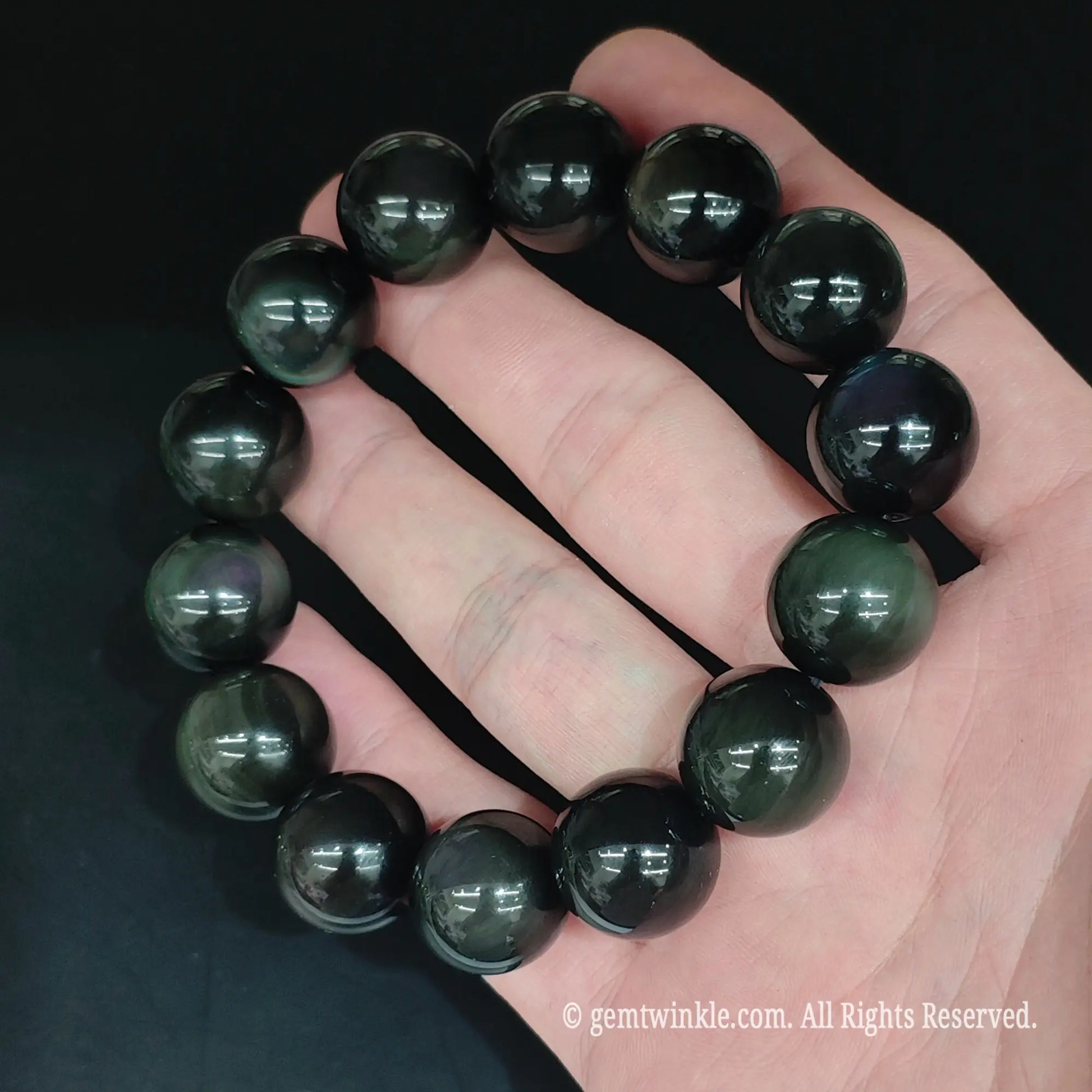 Glossy black rainbow eye obsidian bead bracelet top view showing uniform round bead alignment and mirror polish