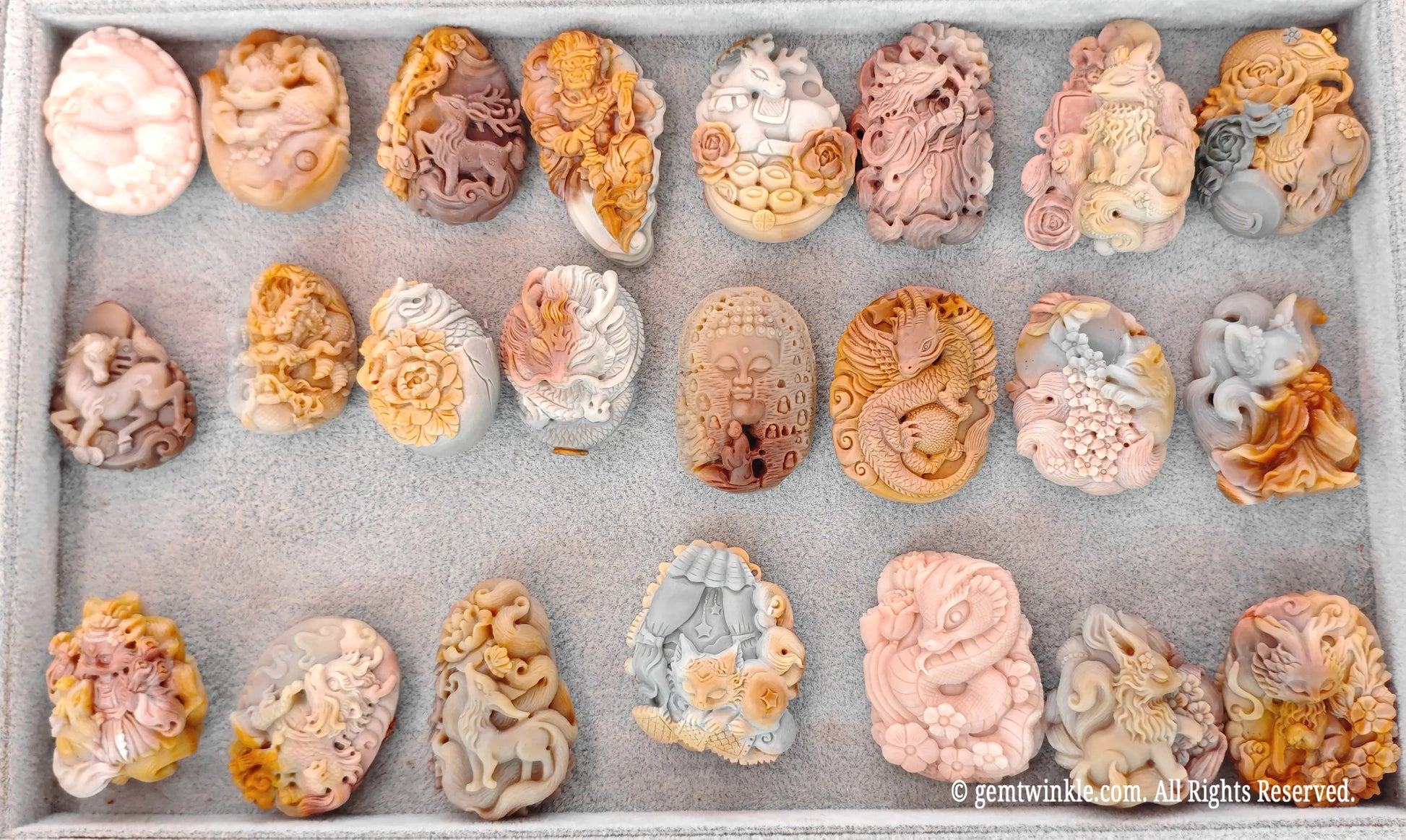 Selection tray of hand-carved Alashan Gobi agate nine-tailed fox relief pieces displaying various natural color tones