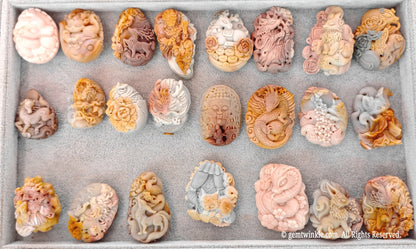 Selection tray of hand-carved Alashan Gobi agate nine-tailed fox relief pieces displaying various natural color tones