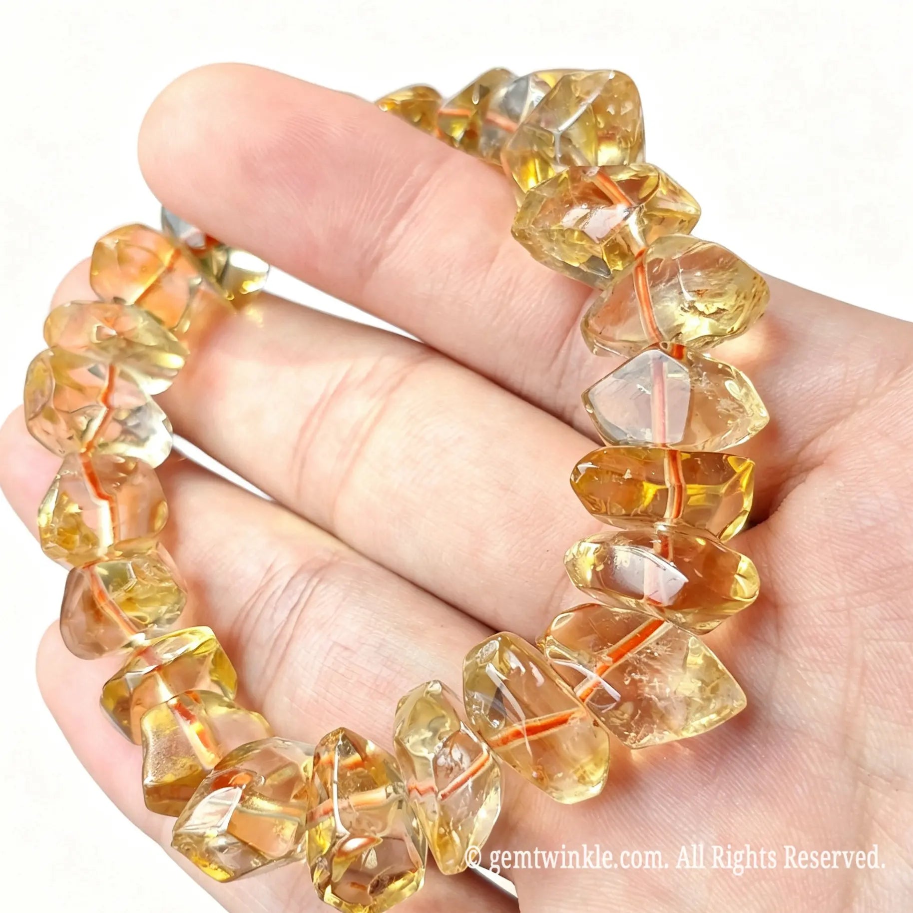Handheld angle view of freeform golden citrine quartz stretch bracelet showing organic bead shapes