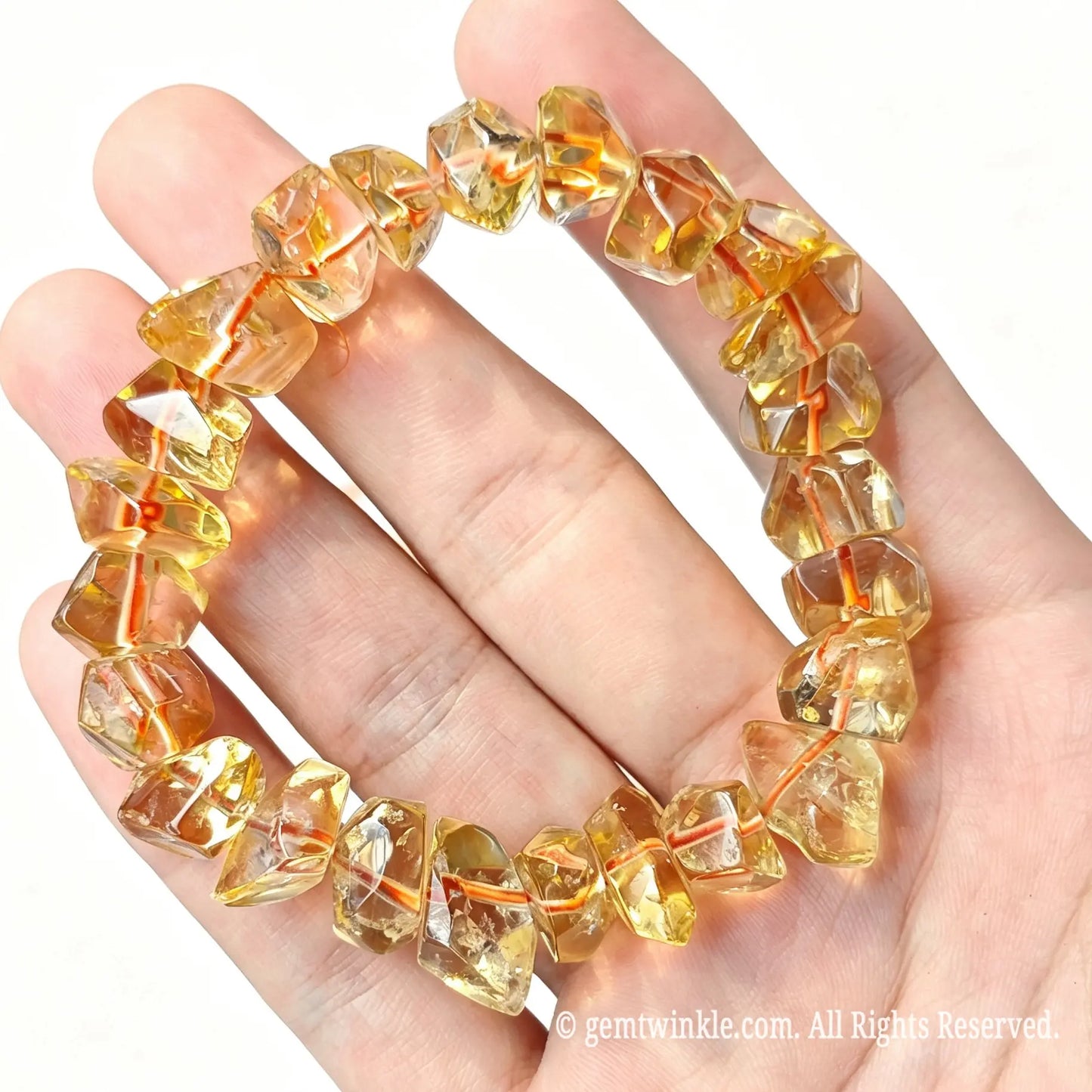 Golden citrine quartz freeform chip stretch bracelet arranged in a loop resting on open hand