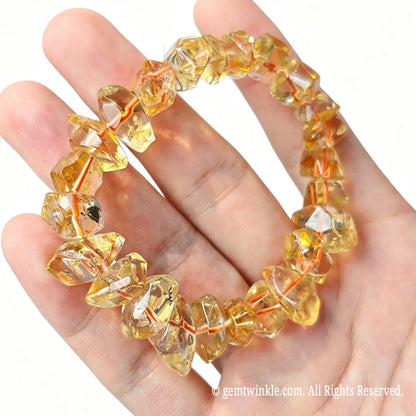 Golden citrine quartz irregular chip bead bracelet resting in palm showing warm honey yellow tones
