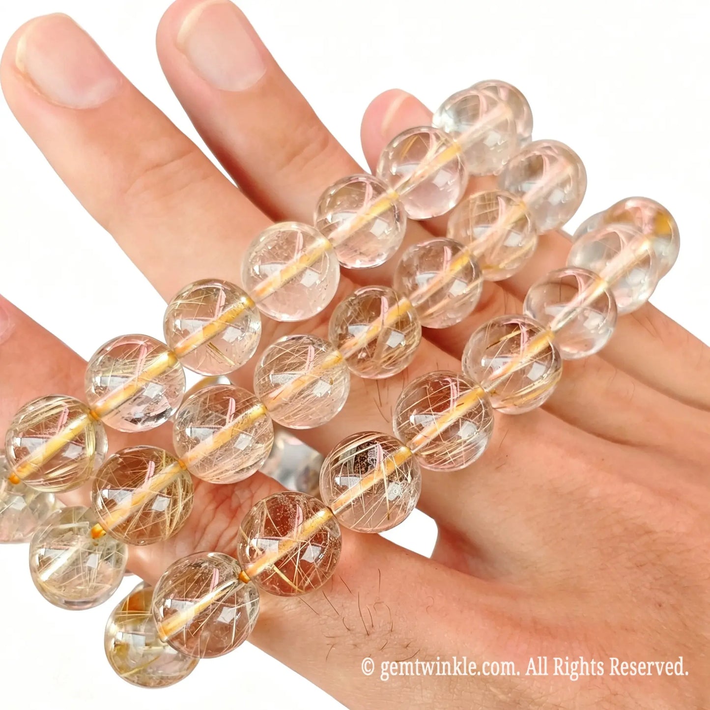 Hand preview of a single-strand golden rutile quartz bead bracelet showing crystal clarity