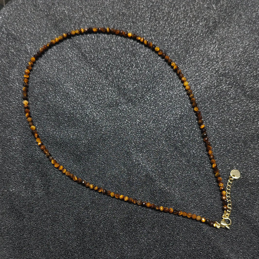 Hand holding 3mm micro faceted Golden Tiger Eye necklace strand showing silky golden brown cat eye chatoyancy