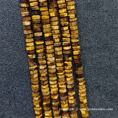Perspective view of golden tiger eye faceted heishi spacer beads showing uniform 3mm disc thickness