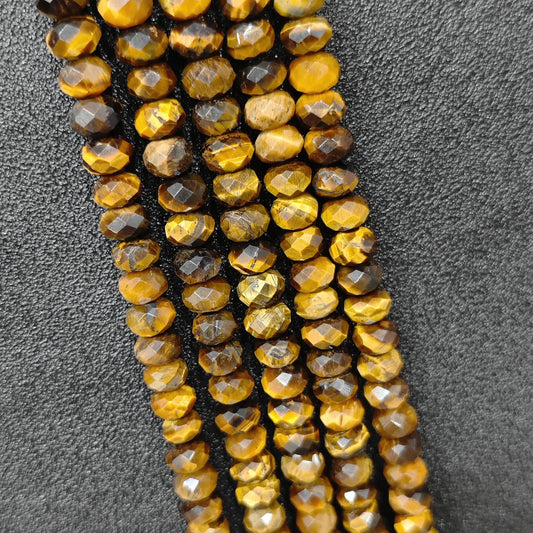 Macro closeup of golden tiger eye faceted rondelle beads showing silky chatoyancy and cut facets