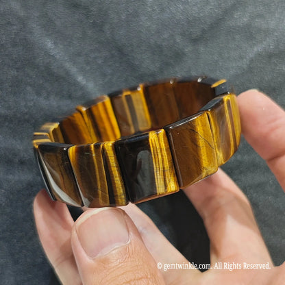 Side view of a golden tiger eye rectangle stretch wristlet displaying silky cat eye effects across flat polished beads[cite: 5]