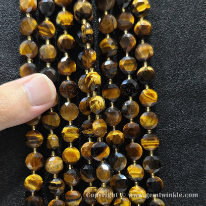 Hand holding strands of 8mm and 10mm golden tiger eye hexagram flat disc beads