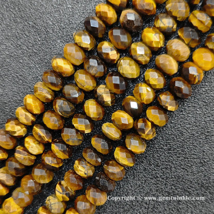 Perspective view of golden tiger eye wheel shape beads showing light reflection on faceted surface