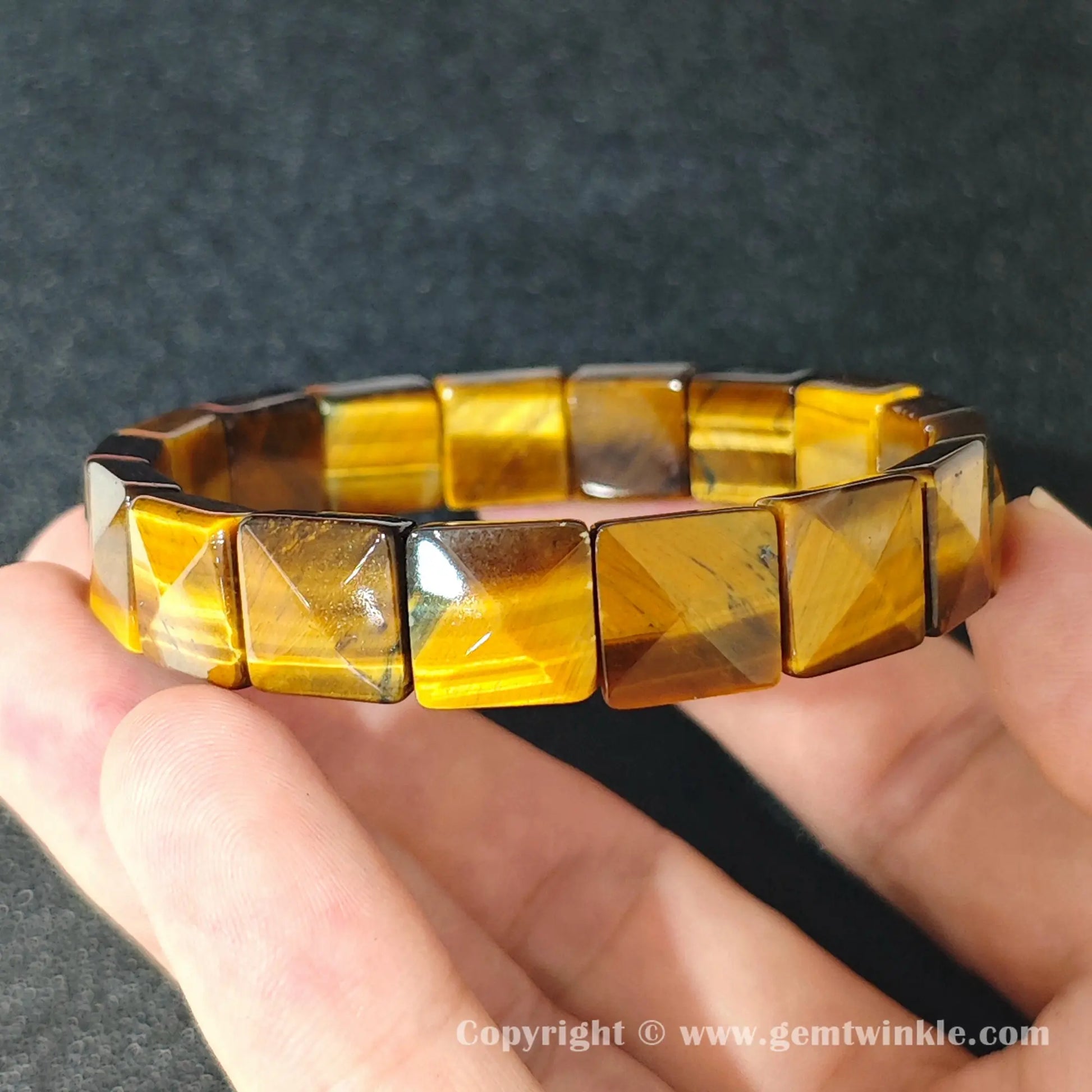 natural yellow tigers eye square plate bracelet displayed over palm highlighting glossy polish