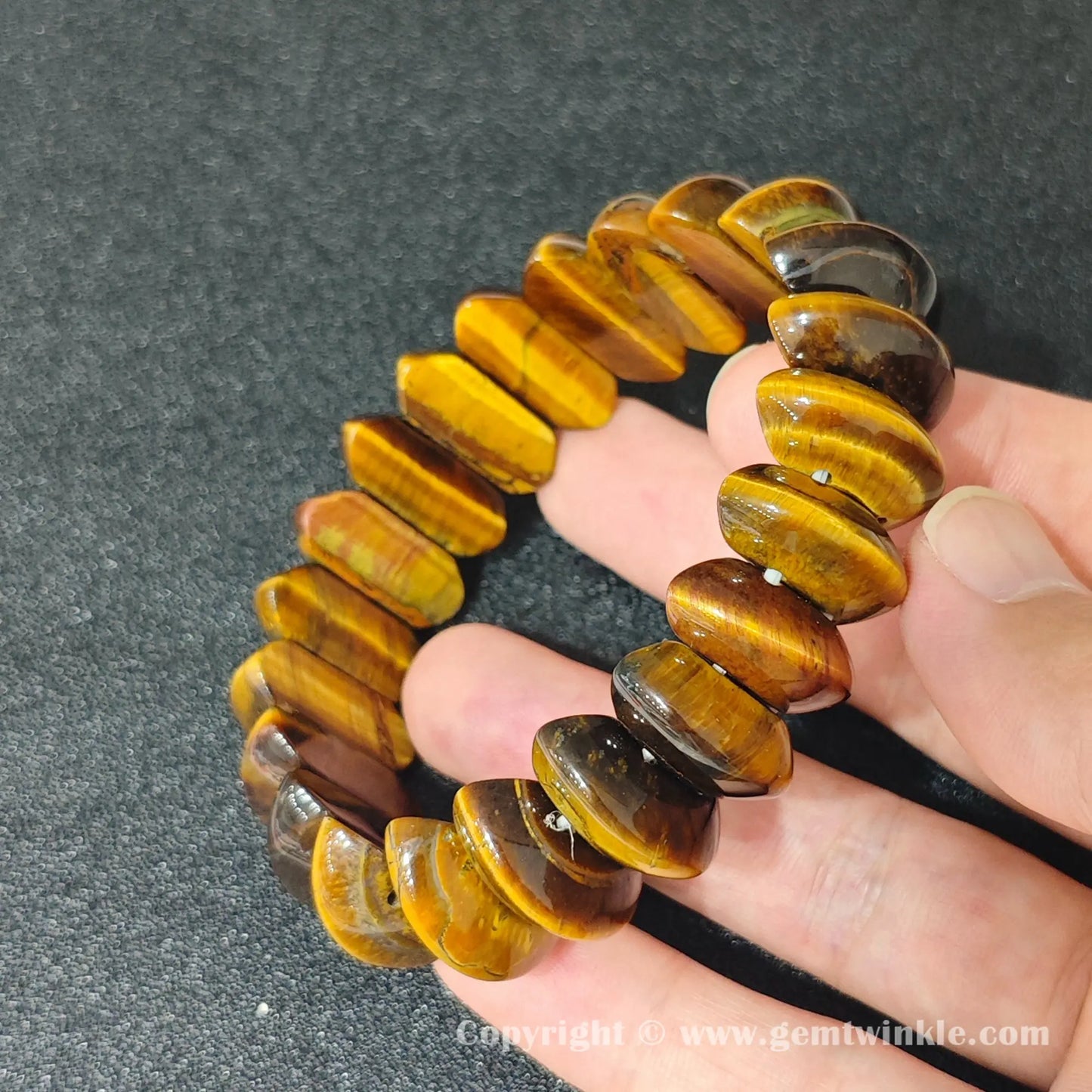 natural yellow tigers eye crescent bead bracelet displayed on fingers showing glossy finish