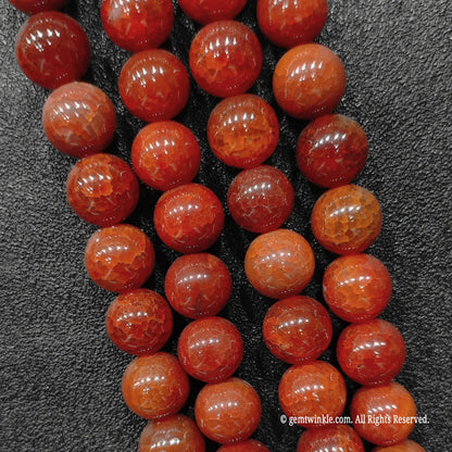 Close up view of gothic red dragon vein agate beads highlighting intense deep blood red coloration and fractured lines