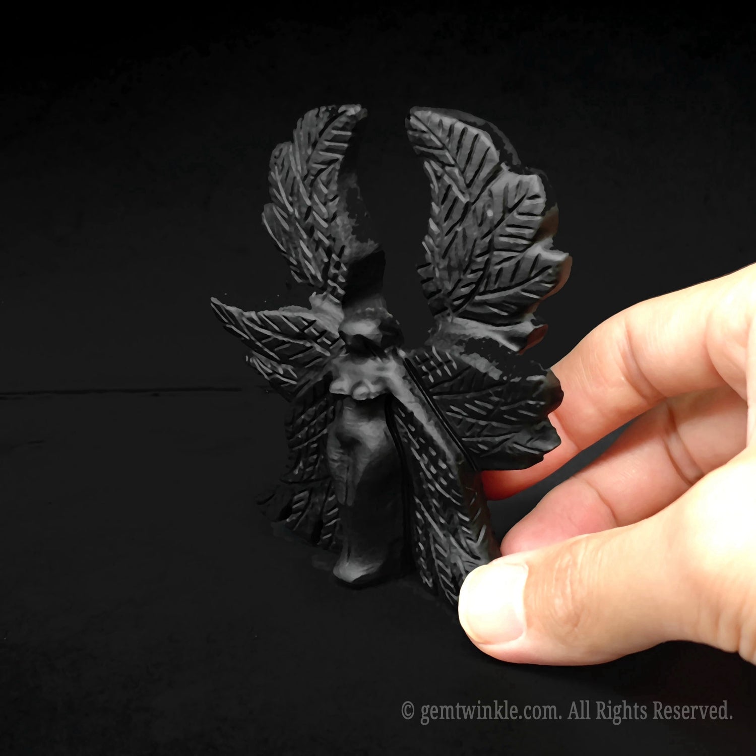 Side angle of the black obsidian gothic Seraphim angel carving held in hand showcasing thickness and polish