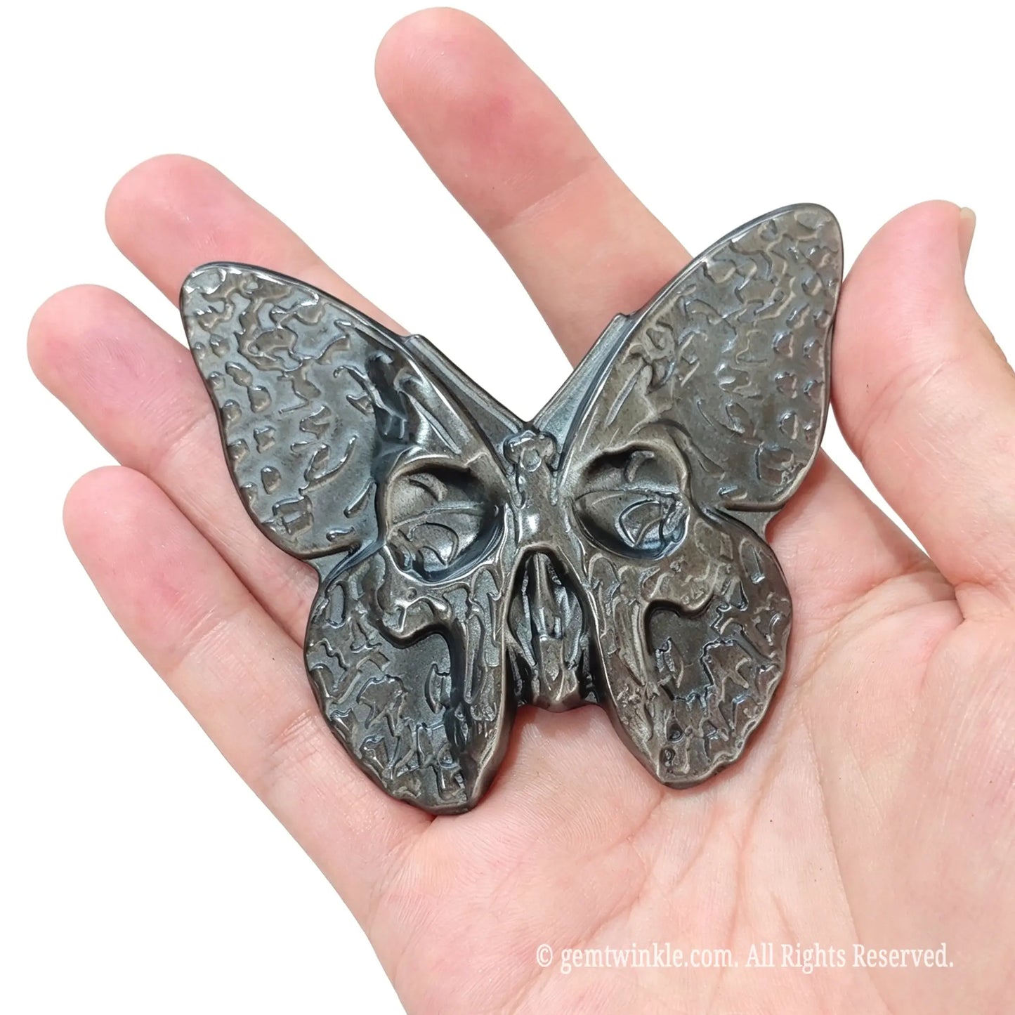 Front view of gothic silver sheen obsidian skull moth figurine 8x5cm resting in hand