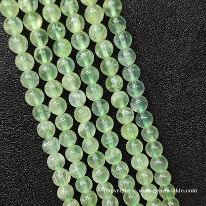 Perspective view of Grade A green prehnite round beads showing polished surface finish across sizes