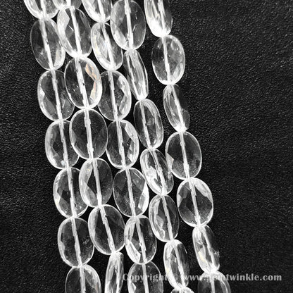 Hand holding 13mm natural clear quartz faceted oval flat beads strand