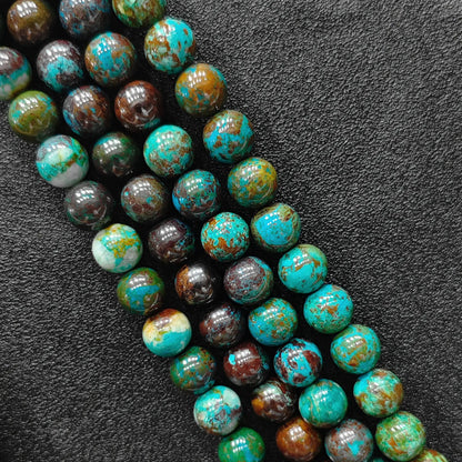 Macro closeup of green chrysocolla phoenix stone smooth round beads showing vibrant matrix pattern