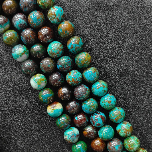Macro closeup of green chrysocolla phoenix stone smooth round beads showing vibrant matrix pattern