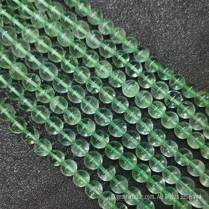 Multiple strands of natural green fluorite loose gemstone beads from Donghai crystal market showing high clarity and uniform sizes