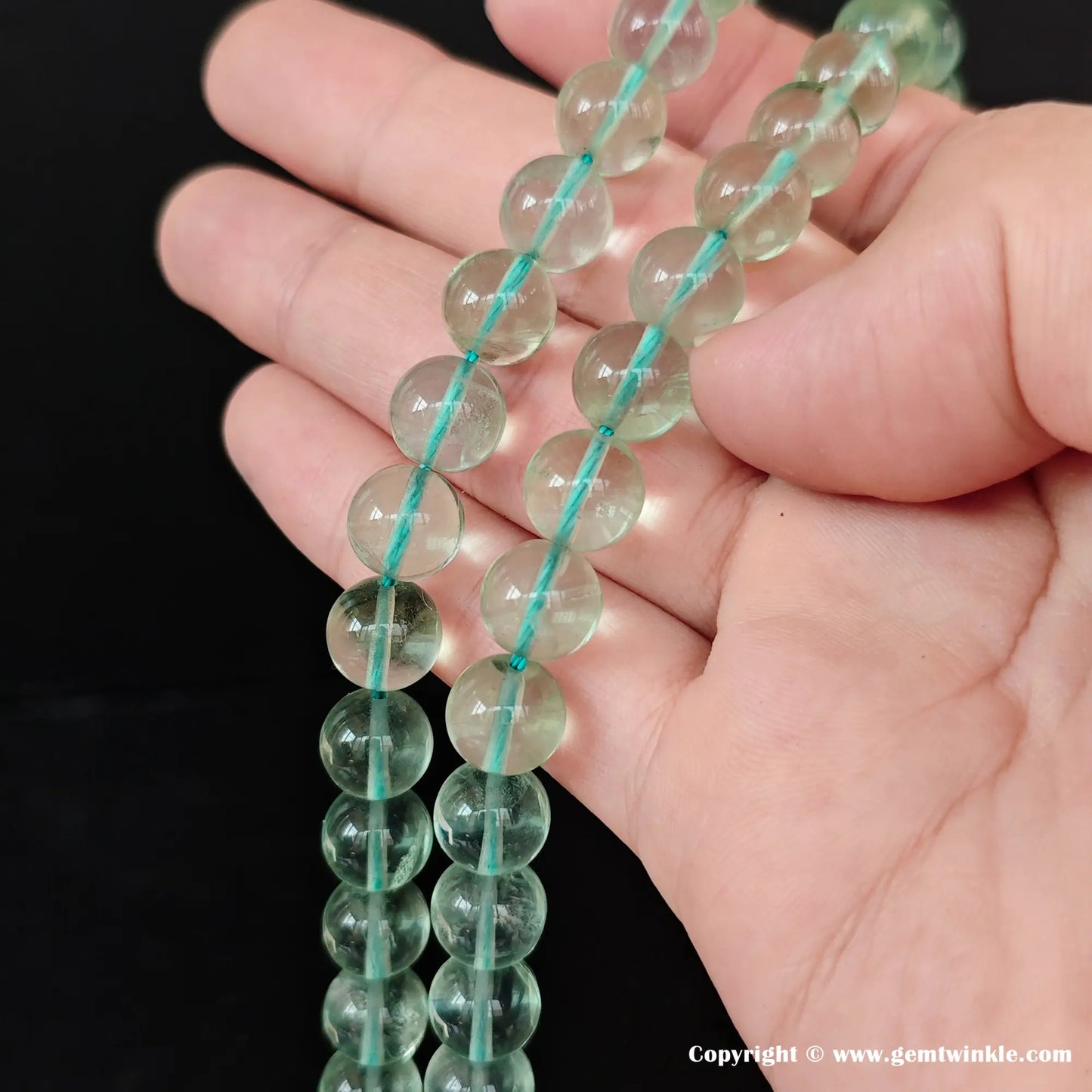 Close up details of premium green fluorite gemstone beads showcasing the smooth surface and translucent texture