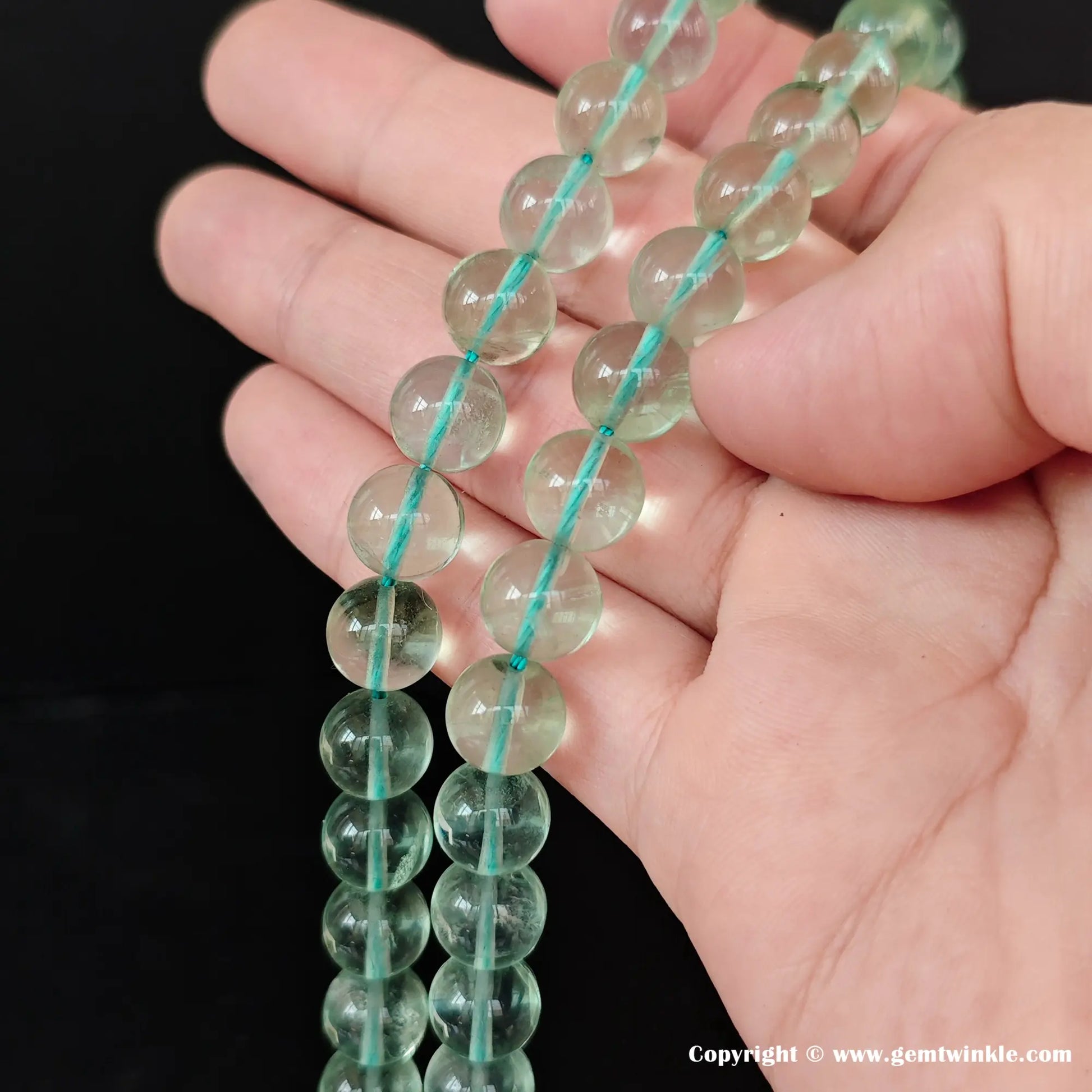 Close up details of premium green fluorite gemstone beads showcasing the smooth surface and translucent texture