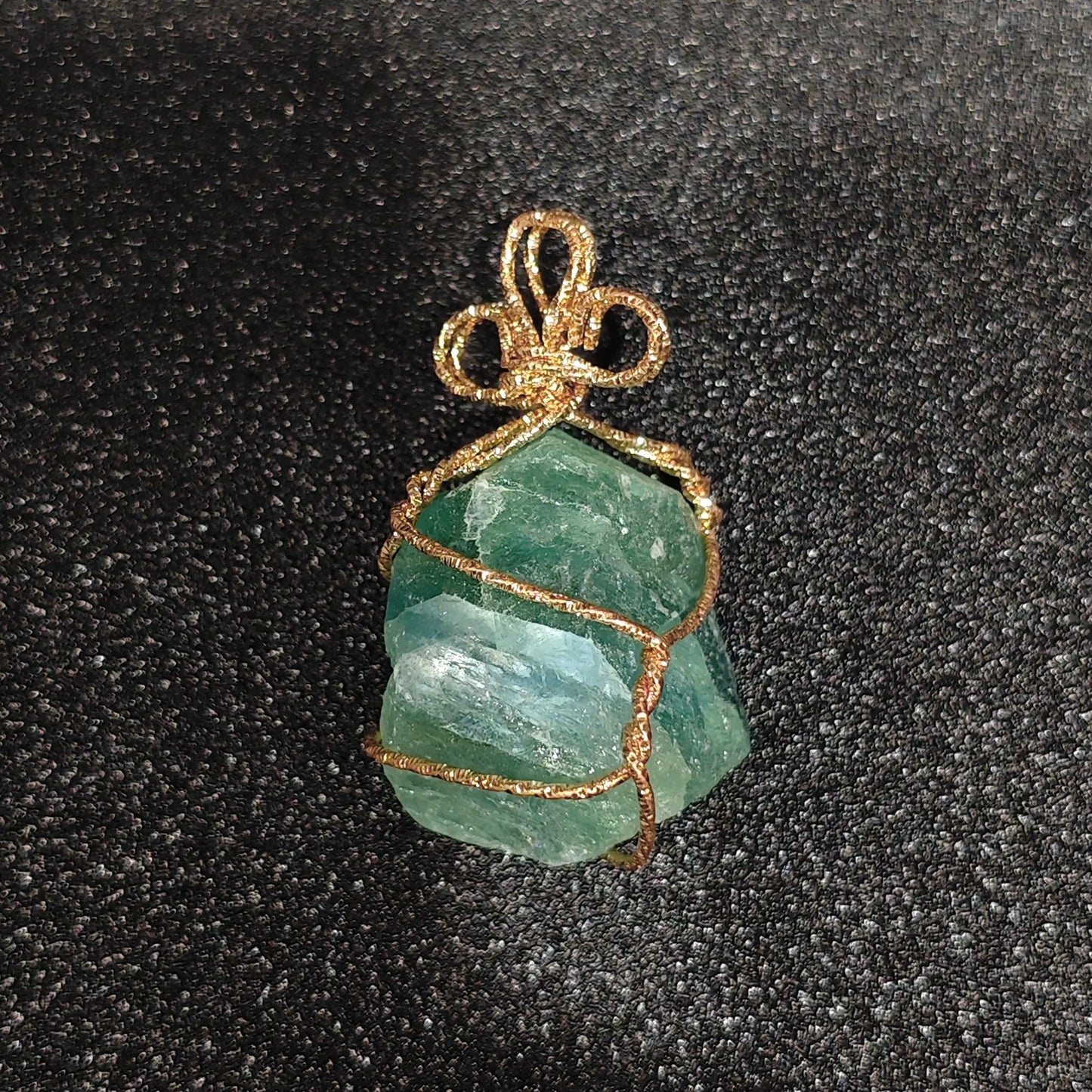 Raw mint green fluorite crystal chunk wrapped in gold-tone craft wire with decorative bow bail